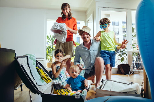 Happy family of five packing for holiday trip
