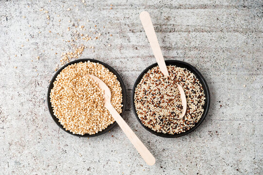 Wholemeal quinoa and popped quinoa in bowls, wooden spoons