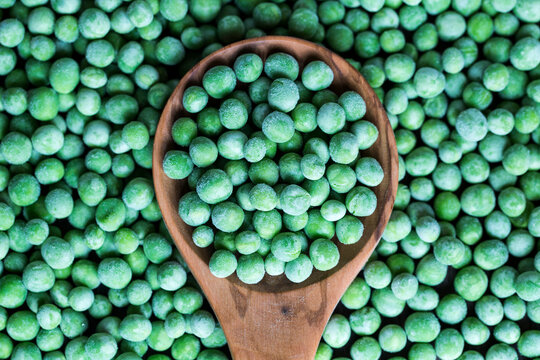 Wooden spoon and frozen peas