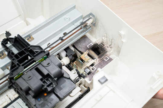 Close-up open inkjet printer showing the printhead and cartridge assembly on rails, internal hardware, mechanisms and parts for repair, maintenance, diagnostics and technical documentation.