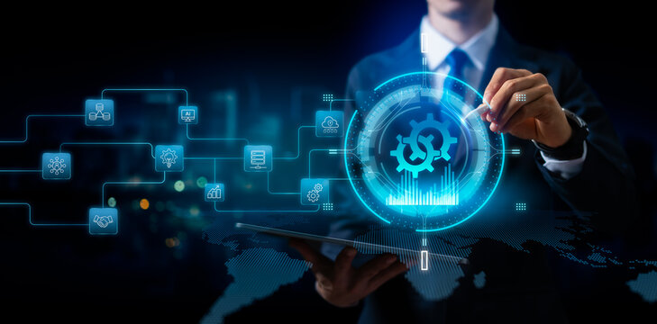 Digital transformation, business process automation and industrial connectivity concept. Businessman holding tablet with glowing gears and tech icons for corporate strategy and global network
