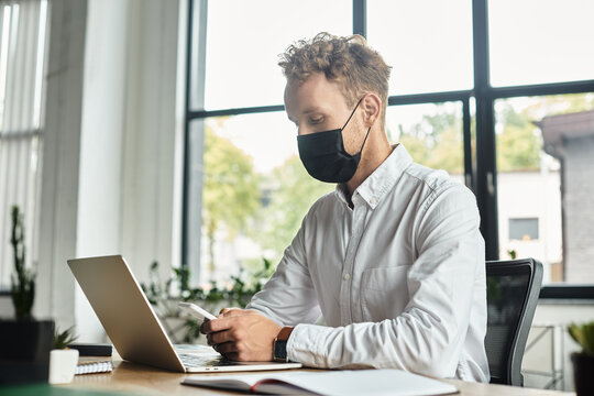 Young handsome man working diligently at his desk in a bright, modern office space