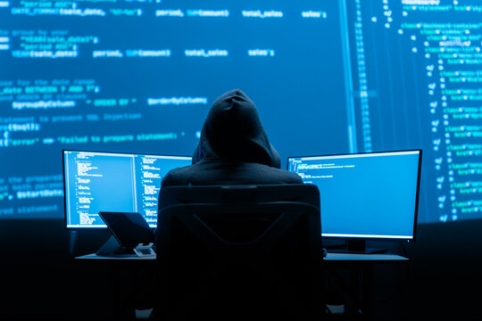 Person Working with Multiple Computer Screens in Dark Room with Coding Data