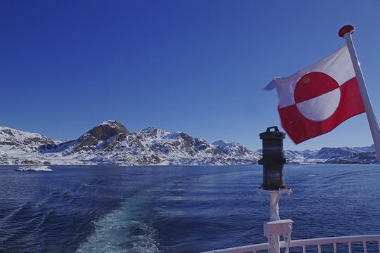 Greenlandic flag waving in the wind at the end of a ship, winter landscape, Sisimuit, Arctic, Greenland, Denmark, North America