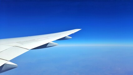 Obraz premium Airplane Wing in Flight Over Blue Sky