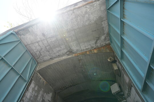 Low angle view of weathered blue industrial gates under concrete.