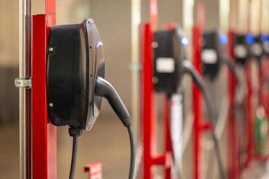 EV charging and electric car, Electric car charging station for charge EV battery, Plug for vehicle with electric engine, EV charger clean energy, Charging point at car parking lot.