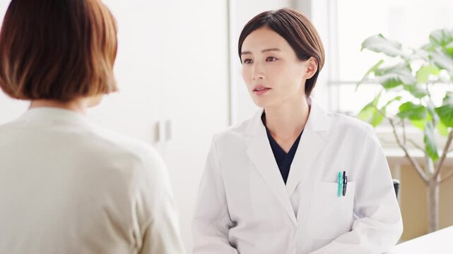 患者を診察する白衣姿の日本人女性医師