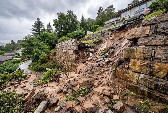 Landslide causing collapse of stone retaining wall near residential house