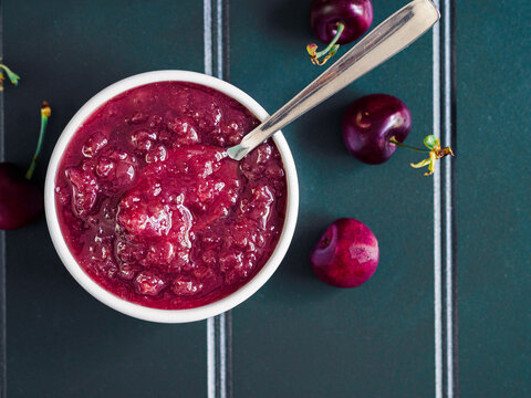 tablespoon of homemade cherry jam with a juicy texture, top view
