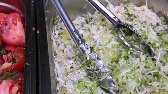 Salads of marinated fresh tomatoes, fresh cabbage, and red onion with thyme in the large bowls, street food, background