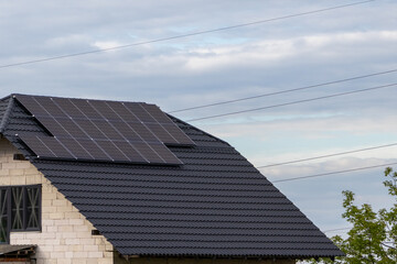 Solar Panels Installed on a Rooftop in a Suburban Area During a Cloudy Day With Power Lines Running in the Background © Роман Булатов