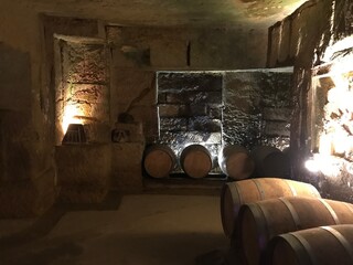 Oak Barrels Aging Wine Inside a Dimly Lit Historic Stone Cave © blueringmedia