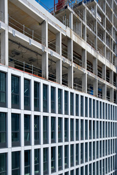 unfinished construction building facade exposes concrete slabs and windows, showing urban site development and city architecture in progress