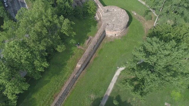 Aerial view of the historic city walls and circular bastion surrounded by lush green parkland and trees in Ferrara, Emilia-Romagna, Italy.