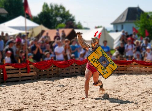 The victorious gladiator greets the audience by raising his weapon to the sky. Roman fest. Swiss Festival recreating various episodes of the daily routine of Romans. 2024 Augusta Raurica, Kaiseraugst