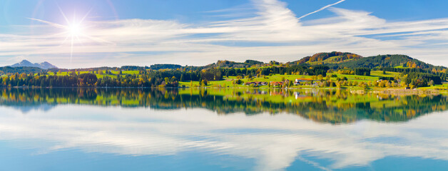 Im Allgäu spiegeln sich die Berge auf der Wasseroberfläche des Forggensee bei Füssen - FOTOMONTAGE © Wolfilser