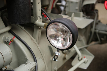 Fototapeta premium Industrial machinery close up with headlight, metal pipes and controls, engineering and maintenance in factory setting for inspection