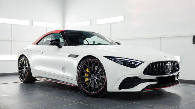 White Mercedes-Benz SL convertible with red soft top isolated on white background. Luxury sports car with elegant design and premium styling. Concept of performance, prestige, and modern automotive