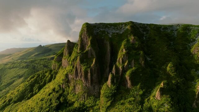 Ancient basalt ramparts draped in vibrant, windswept greenery, standing in solemn solitude against the backdrop of an untamed Atlantic sky.