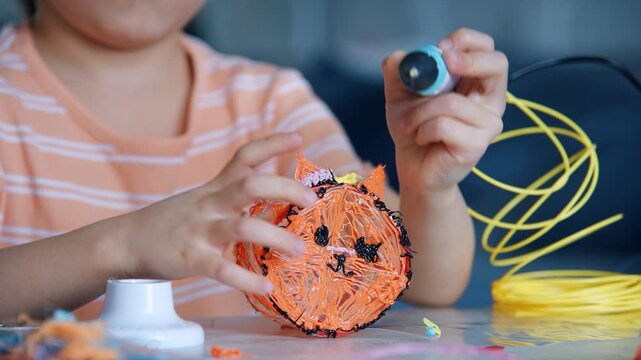 Close up little girl using 3D pen to create plastic toy figure, slow motion video of creative technology activity for children