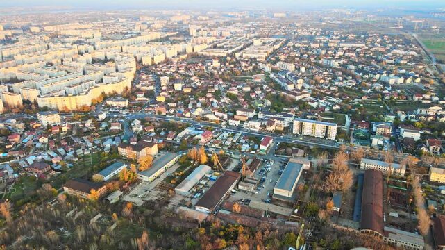 Aerial view of suburban landscape with residential apartment blocks and industrial zone at sunset.