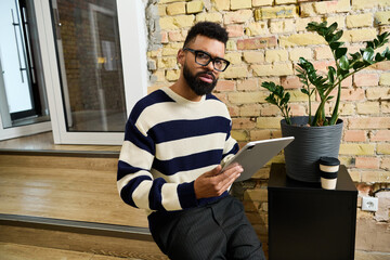 Fototapeta premium Young handsome man engages in creative work at a cozy modern workspace with stylish decor