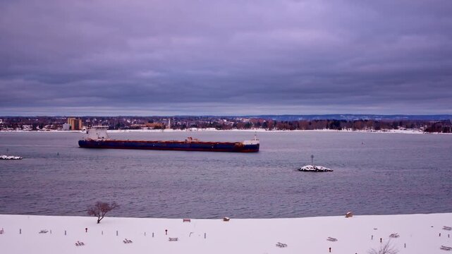 Aerial winter shot of a freighter carving through frozen sections of the St. Marys River.