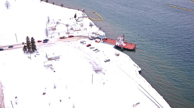 Aerial drone footage of a car ferry crossing the river between Sugar Island and the Upper Peninsula of Michigan.