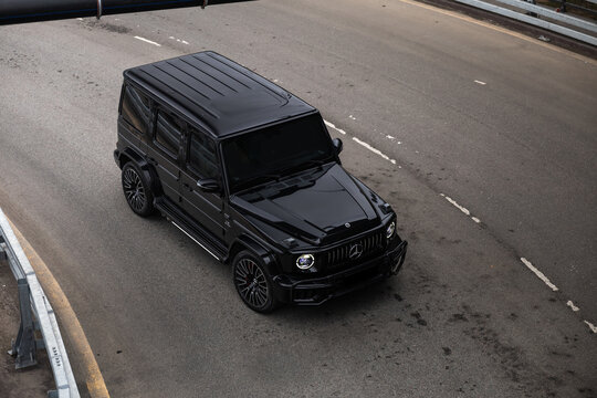 Black Mercedes-Benz G-Class AMG in urban city setting on asphalt road. Luxury SUV with iconic design, powerful presence, and premium styling. Concept of prestige, status, performance and modern