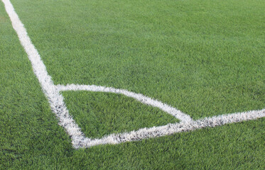 close up of a soccer field corner showing white boundary lines on green grass with precise markings and outdoor sports setting © RATOCA