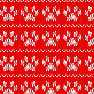 Knitted seamless pattern with paw prints on red background