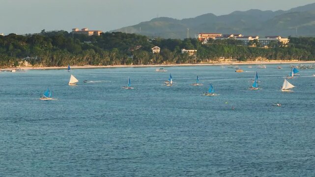 Paraw sailing boats running over the sea. Sunset in Boracay, Philippines.