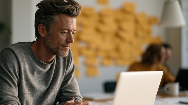 AI search engine product manager reviewing user intent clustering visualization on laptop during standup meeting, post-it covered wall behind team, afternoon light, SEO taxonomy and AI search evolut