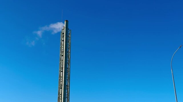 Industrial pipe white smoke blue sky, gas boiler stack rising into clear sky, frost coating metal surface, crisp winter light