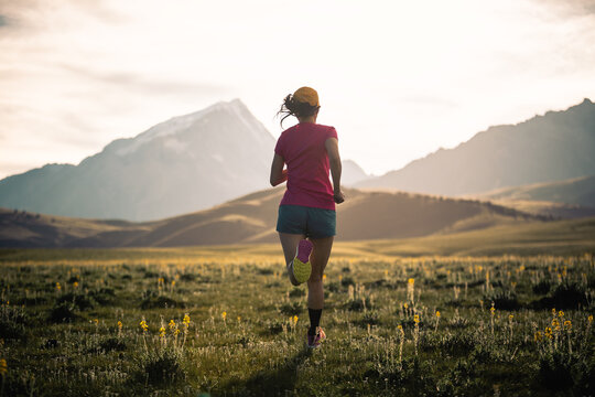 Trail runner running on the high altitude grassland mountain top