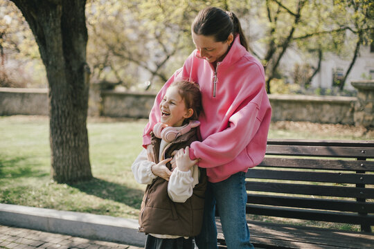 Happy mother and daughter relaxing in a park on sunny day.