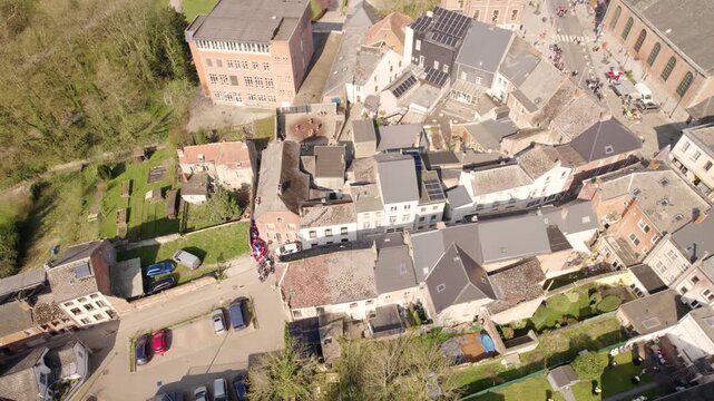 Festive Street Carnival in Small Belgian Town, Crowd Gathering Near Church and Historic Buildings in Beaumont - Aerial Drone Shot