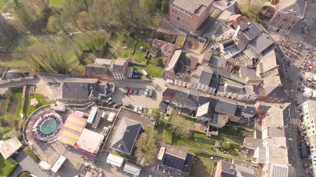 Buildings, Gathering Street Crowd, And Fairground In Beaumont Village, Wallonie, Belgium. aerial orbiting shot