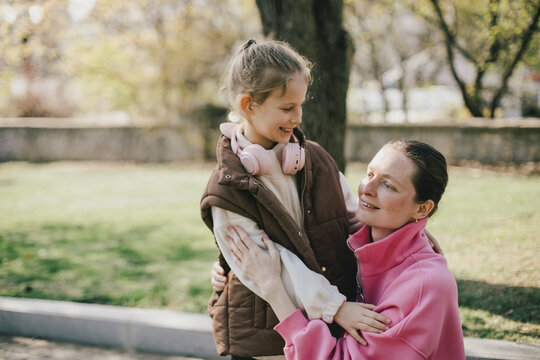 Happy mother and daughter relaxing in a park on sunny day.