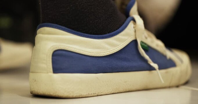 Close-up view of an operating method how to use heel puller metal tool with a shoe in home environment before go away.