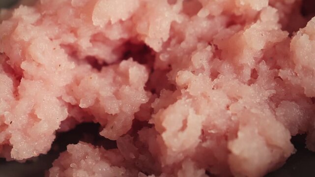 Close-up of raw ground chicken texture. Cooking process, food preparation and protein ingredient concept. High quality 4k footage