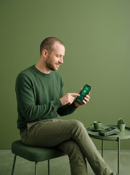 Man using smartphone for contactless payment on NFC terminal