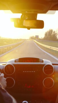 Person drive the car towards the sunset in slow motion