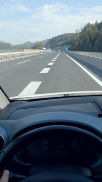 Driver POV behind the steering wheel driving car on highway AC