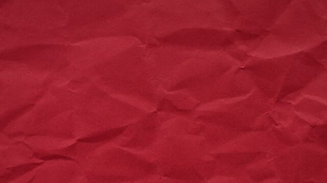 Vibrant red wrinkled paper texture seamless loop. Energetic stop-motion animation for creative video overlays and bold artistic backgrounds.