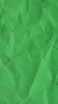 Green wrinkled paper animation in vertical format. Seamless stop-motion loop for mobile content, professional ads, and creative layouts.