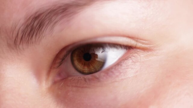 Extreme close-up of a human eye with brown iris and detailed skin texture