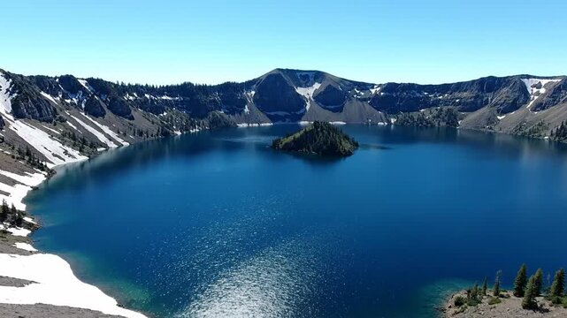 A stunning high-angle shot showcasing a majestic, deep blue lake in a mountain caldera