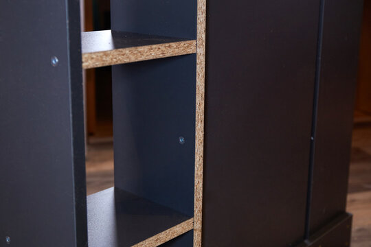 Wooden shelf unit is being assembled in a room with natural light on a weekday in the afternoon
